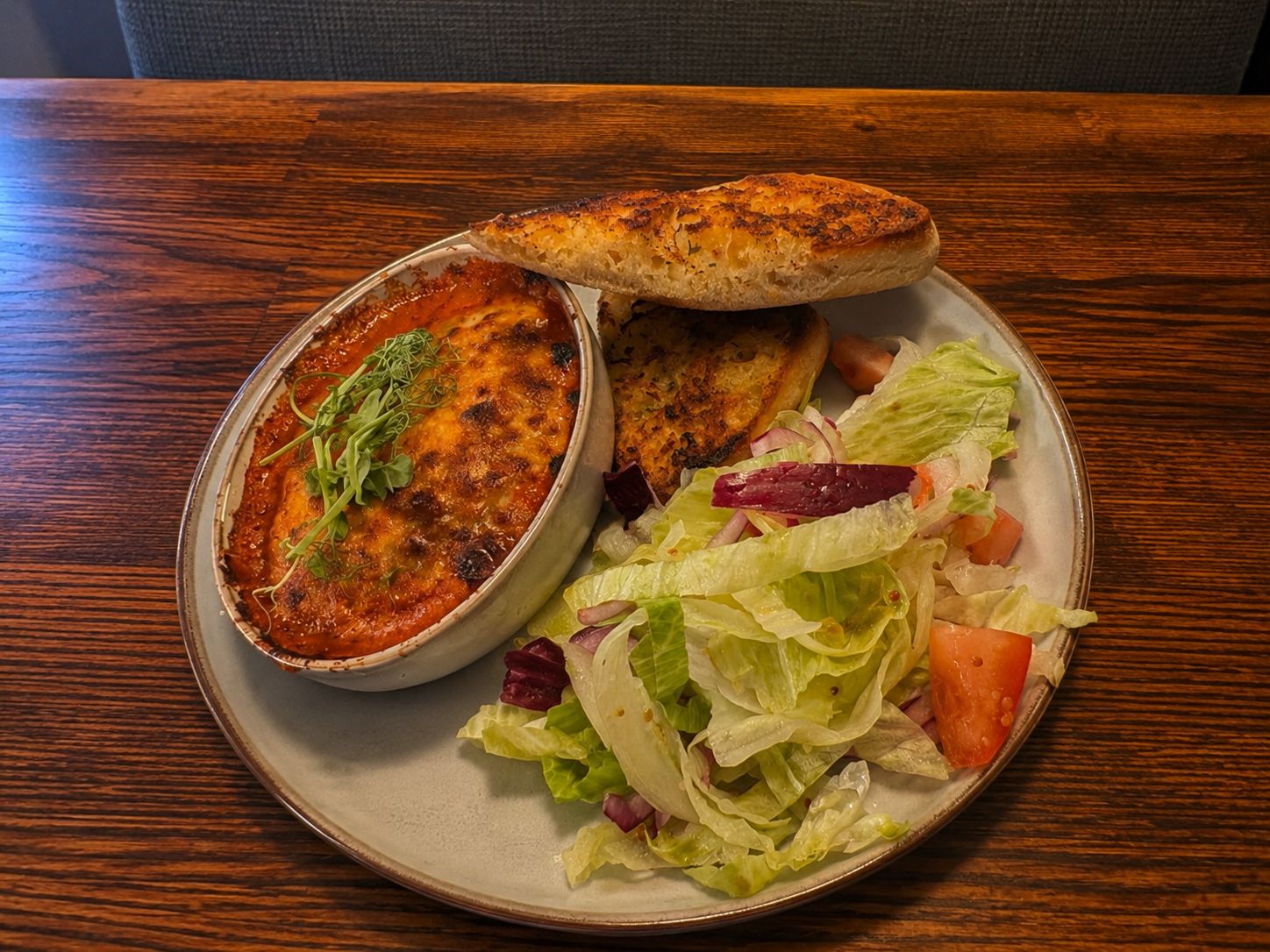 Homemade lasagne with garlic bread and salad